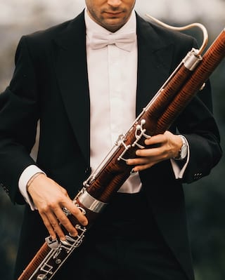 Close-up of hands pressing keys on a shiny clarinet