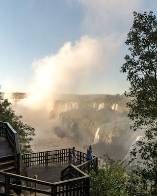 A couple photographing the Iguassu Falls at sunrise