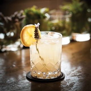 Close-up of a lemony cocktail with lemon and lavender garnish