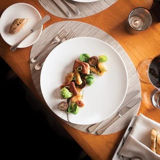 Birds-eye view of pork-belly dish on a white circular plate