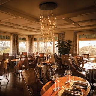 Wide-angle of a restaurant with polished wood floor and modern chandelier
