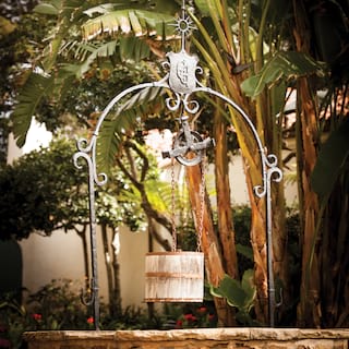 Close-up of a stone-built wishing well, with a hanging wooden bucket