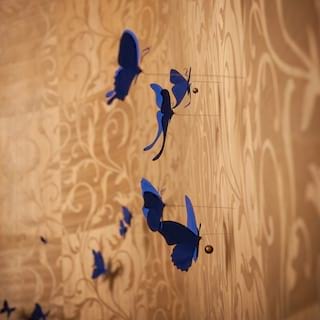 Close-up view of blue decorative butterflies pinned to a patterned wall
