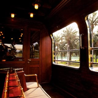 Gleaming open-air train observation carriage with banquette seating in the centre