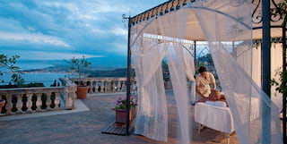 Massage table under an ornate wrought-iron pergola on an Italian villa terrace