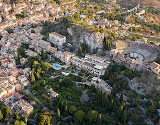 Aerial shot of Taormina with views of an ancient Greek theatre and grand residences