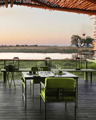 Shaded veranda with an elegant seating area and views across grasslands at sunset